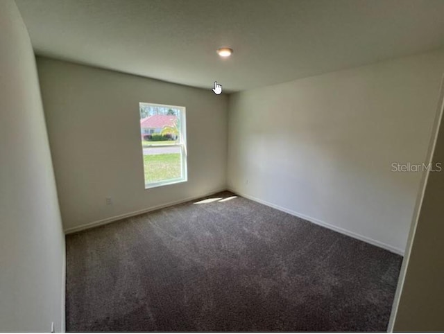 carpeted empty room with baseboards