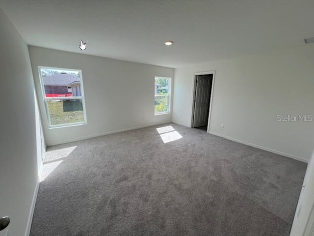 spare room featuring baseboards and carpet