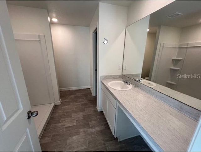 bathroom featuring vanity, recessed lighting, and walk in shower