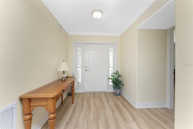 foyer featuring light wood finished floors, visible vents, baseboards, and ornamental molding