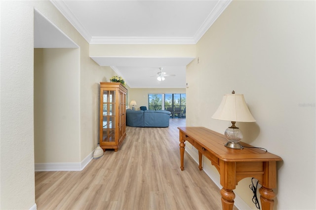 hall with baseboards, light wood-style floors, and crown molding
