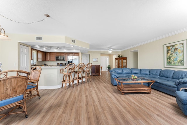 living area with light wood-type flooring, a ceiling fan, and visible vents