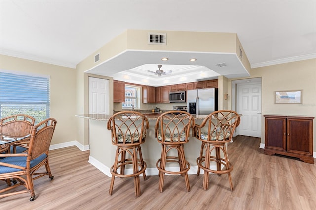 kitchen featuring crown molding, visible vents, appliances with stainless steel finishes, and light wood-style floors