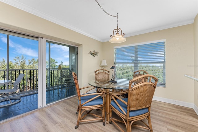 dining room featuring baseboards, ornamental molding, and light wood-style flooring