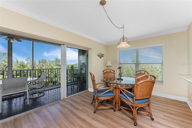 dining area with light wood finished floors, crown molding, and baseboards