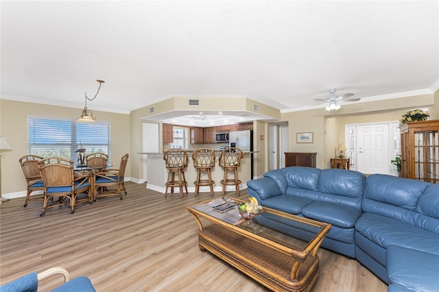living area with light wood-style floors, visible vents, baseboards, and ornamental molding
