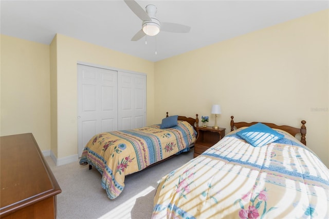 carpeted bedroom with a ceiling fan, baseboards, and a closet