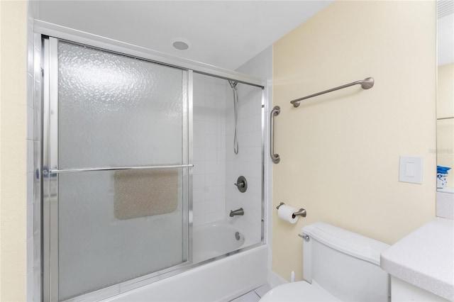 full bathroom with toilet and shower / bath combination with glass door