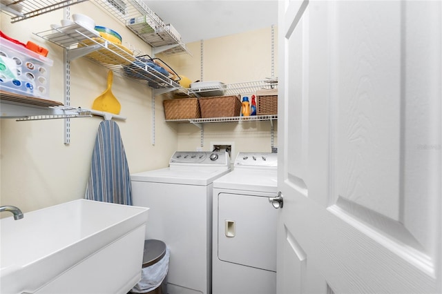 washroom with a sink, laundry area, and washer and dryer