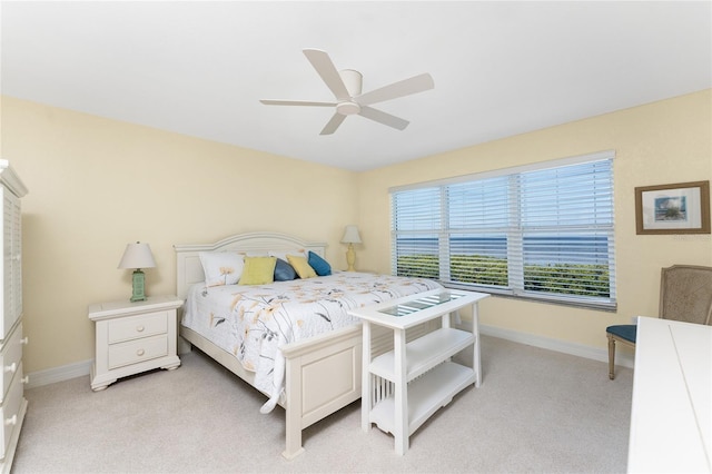 bedroom with light carpet, baseboards, and a ceiling fan