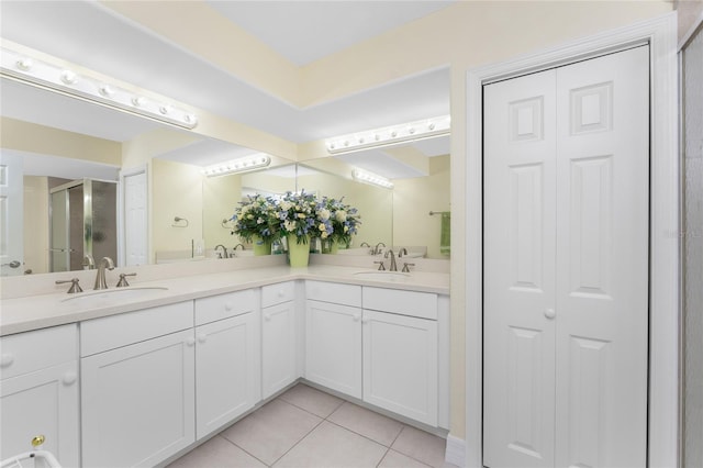 bathroom featuring tile patterned floors, a closet, a sink, and double vanity