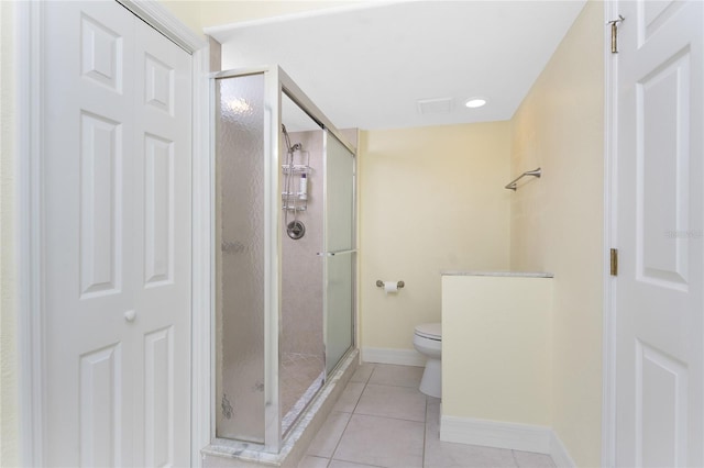 bathroom featuring a stall shower, toilet, baseboards, visible vents, and tile patterned floors