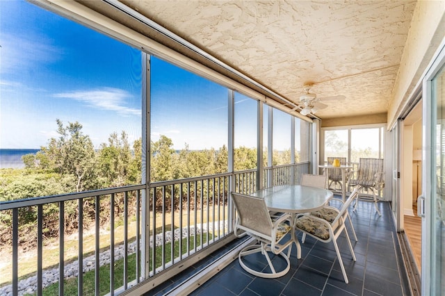 sunroom with ceiling fan and outdoor dining space