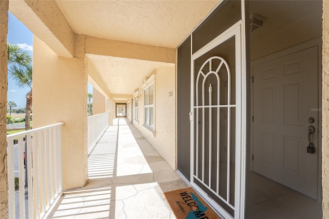 entrance to property featuring stucco siding and a balcony