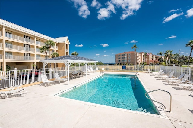 community pool with a gazebo, a patio, and fence