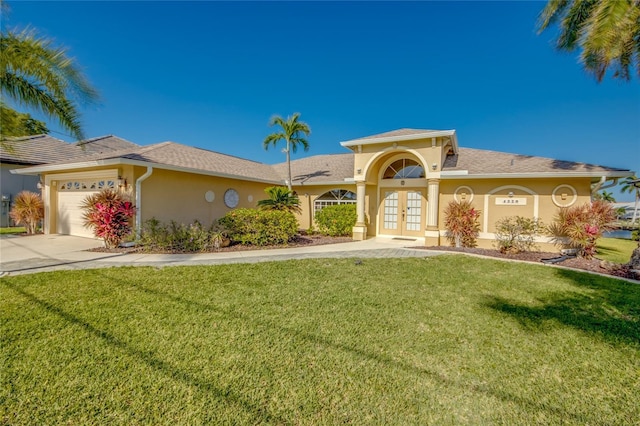 4320 SW 26th Ave, Cape Coral, FL 33914 - view of front of house with french doors, a front yard, a garage, concrete driveway, and stucco siding