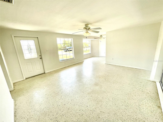 interior space featuring baseboards, visible vents, and ceiling fan
