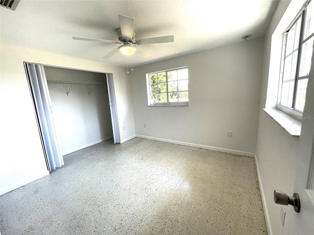 unfurnished bedroom featuring baseboards, a closet, visible vents, and speckled floor