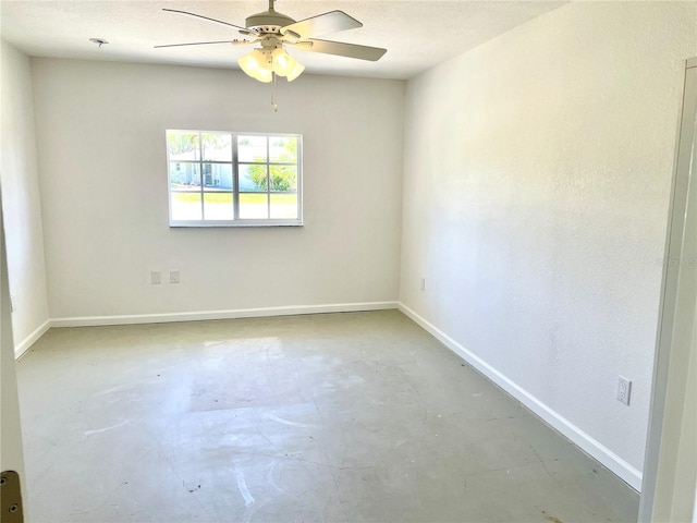 empty room featuring unfinished concrete floors, baseboards, and ceiling fan