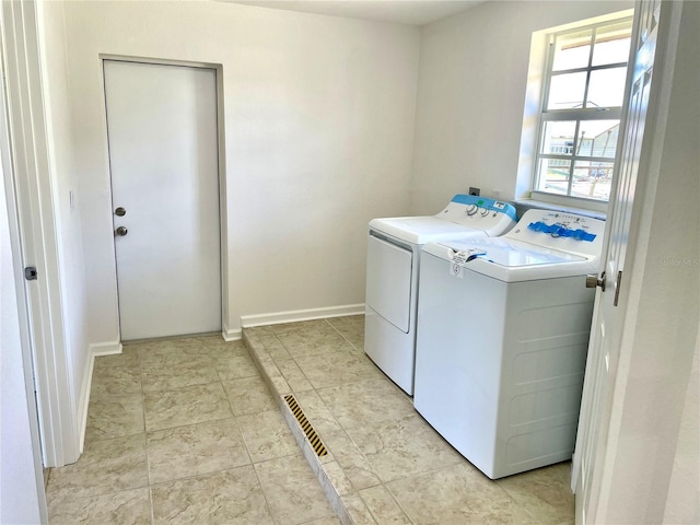clothes washing area featuring separate washer and dryer and laundry area