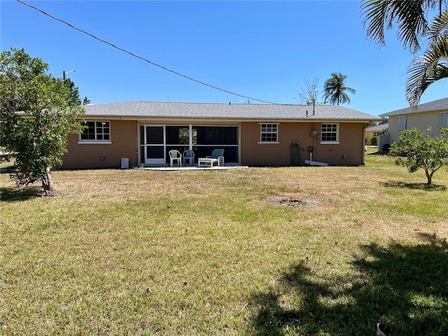 rear view of property with a lawn