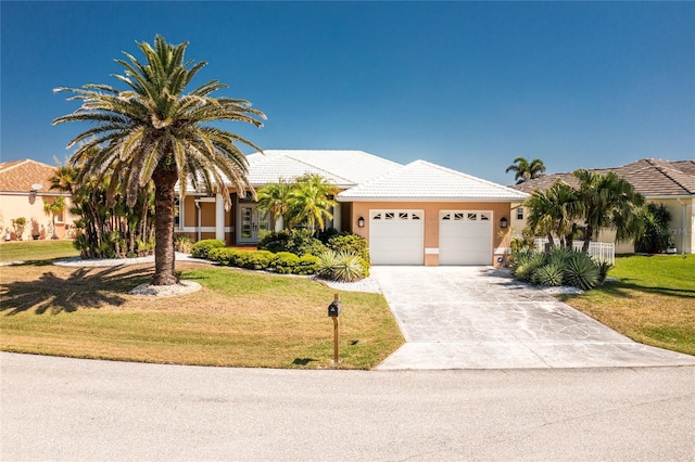 view of front of house with a garage, a front lawn, stucco siding, and concrete driveway