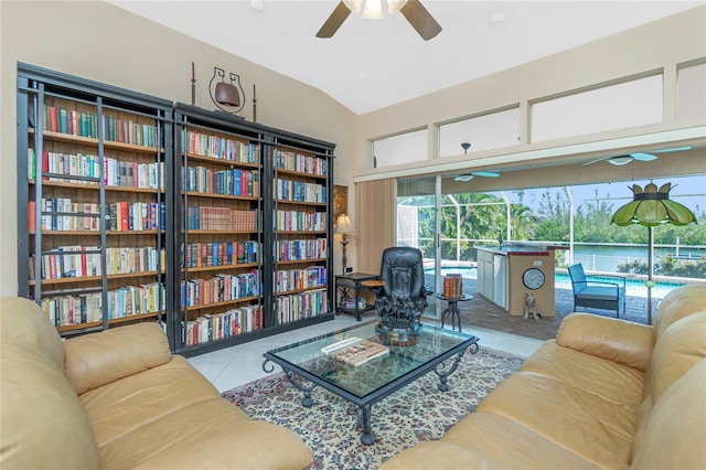 living room featuring ceiling fan, vaulted ceiling, and tile patterned flooring