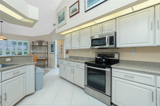 kitchen featuring decorative light fixtures, light countertops, a sink, stainless steel appliances, and light tile patterned flooring