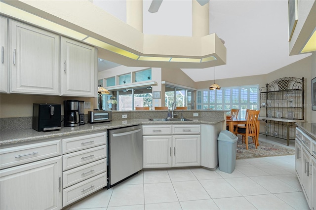 kitchen featuring white cabinets, a sink, a peninsula, decorative light fixtures, and stainless steel dishwasher