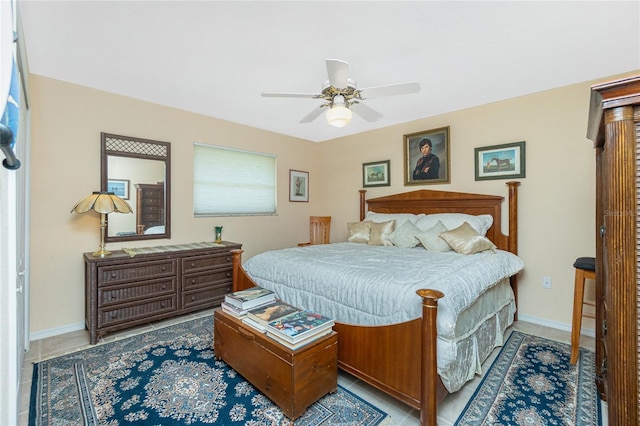 tiled bedroom with baseboards and a ceiling fan
