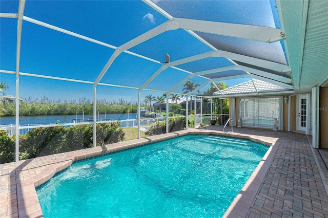 outdoor pool featuring a lanai, a water view, and a patio area