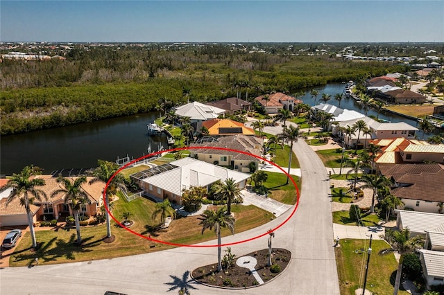 drone / aerial view featuring a water view, a view of trees, and a residential view