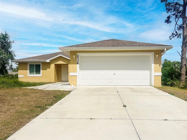 ranch-style home with stucco siding, an attached garage, and driveway