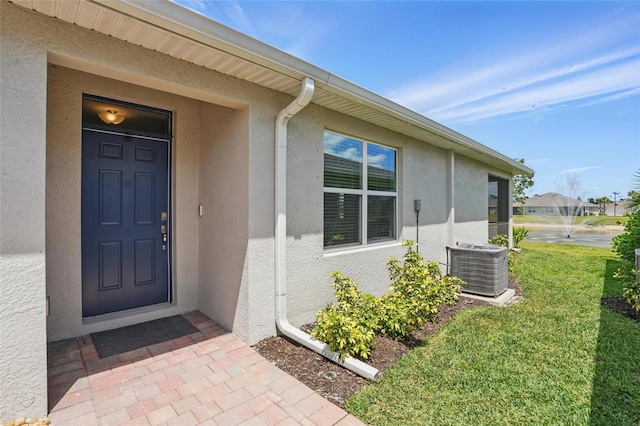 16079 Bandermill Dr, Port Charlotte, FL 33953 - doorway to property featuring stucco siding and central AC unit