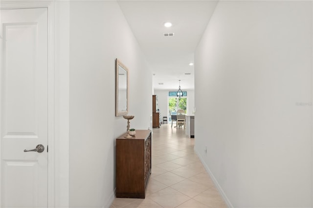 hall featuring light tile patterned floors, recessed lighting, and baseboards
