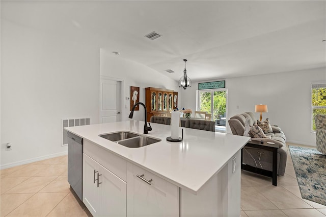 kitchen featuring a sink, dishwasher, open floor plan, light tile patterned flooring, and lofted ceiling