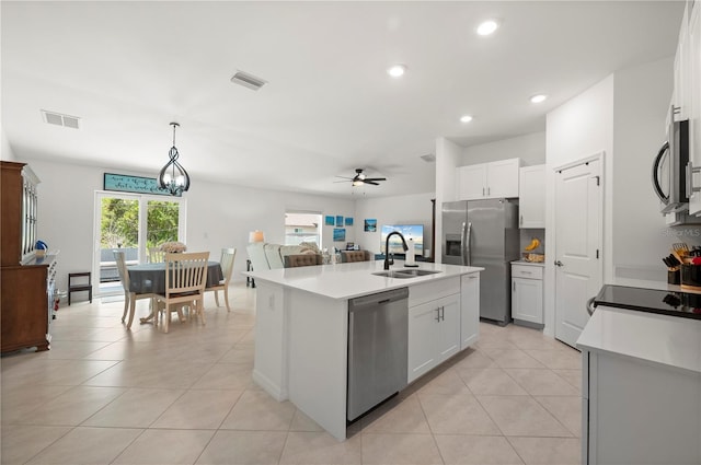 kitchen with stainless steel appliances, ceiling fan, an island with sink, light tile patterned flooring, and pendant lighting