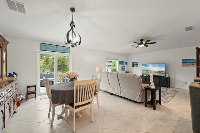 dining space featuring ceiling fan, a chandelier, and light tile patterned flooring