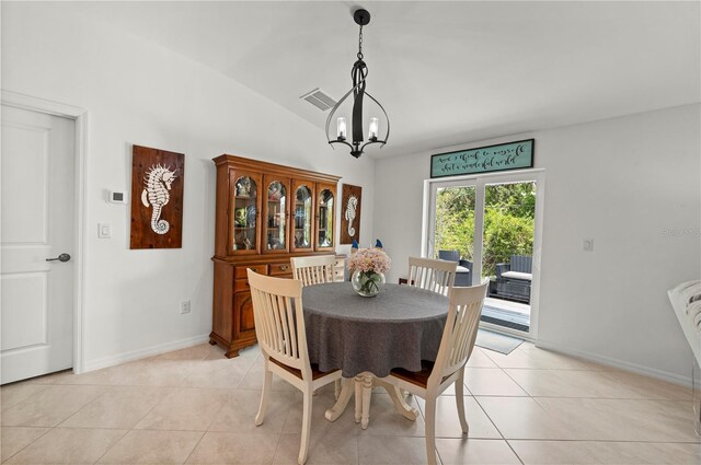 dining area featuring a chandelier, light tile patterned floors, baseboards, and lofted ceiling