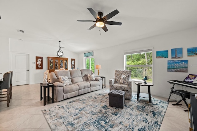 living room with lofted ceiling, light tile patterned floors, and a ceiling fan