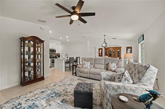 living room featuring ceiling fan, light tile patterned floors, vaulted ceiling, baseboards, and recessed lighting
