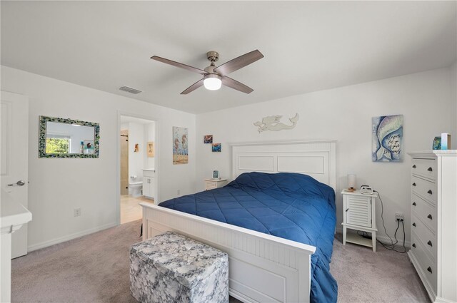 bedroom featuring light carpet, ensuite bath, baseboards, and ceiling fan