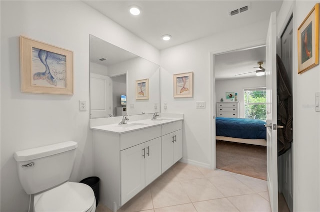 full bath featuring ensuite bath, toilet, tile patterned floors, double vanity, and baseboards