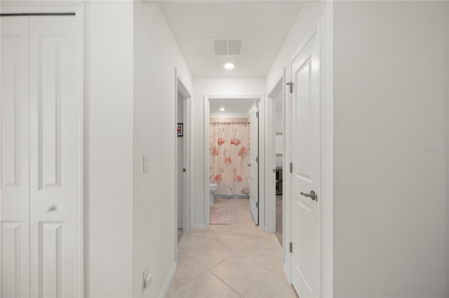 hallway with light tile patterned floors, baseboards, and recessed lighting