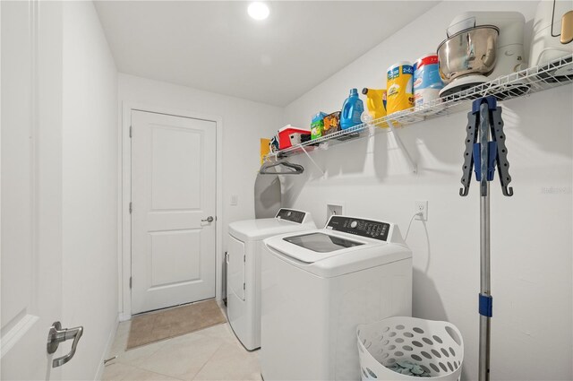 laundry area featuring washer and dryer and light tile patterned flooring