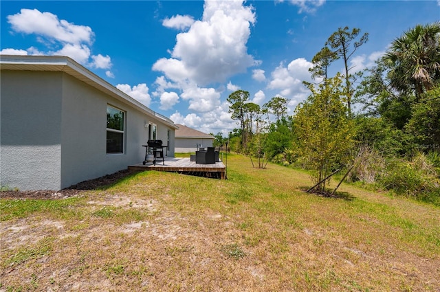 view of grassy yard featuring a wooden deck