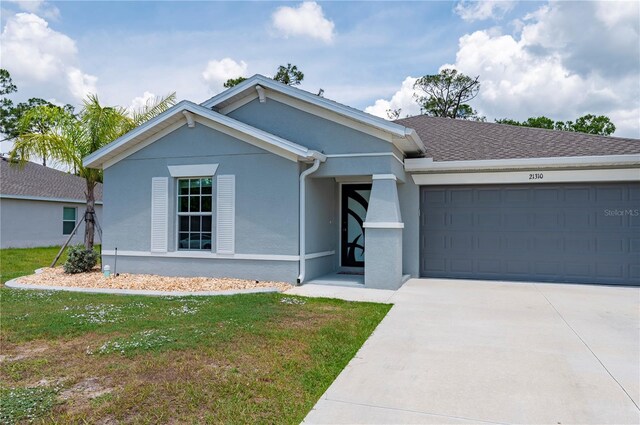 ranch-style house featuring stucco siding, an attached garage, concrete driveway, and a front lawn