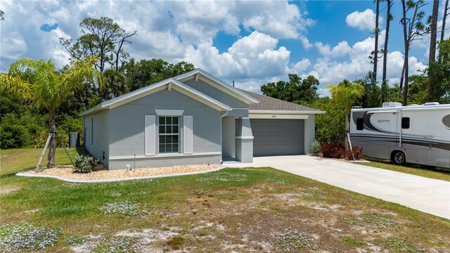 view of front facade featuring stucco siding, a garage, driveway, and a front yard
