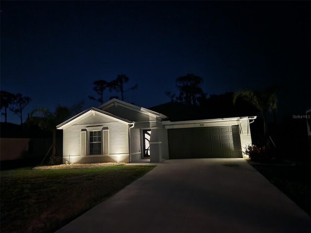 single story home with a garage, driveway, and stucco siding