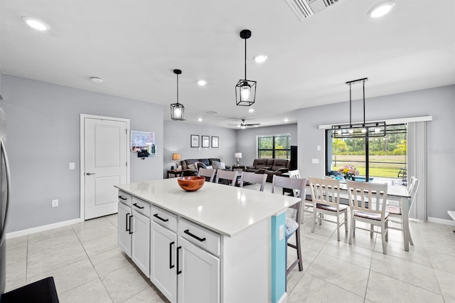 16016 Shoebutton Ct, North Fort Myers, FL 33917 - kitchen with light countertops, white cabinetry, recessed lighting, light tile patterned floors, and a kitchen island